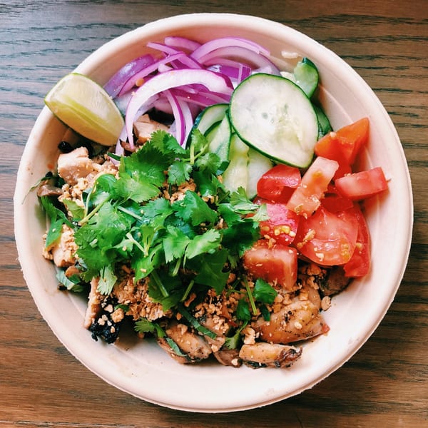 Mighty Bowl's Asian-fusion bowl with chicken, cilantro, red onion, cucumber, tomatoes, and lime.