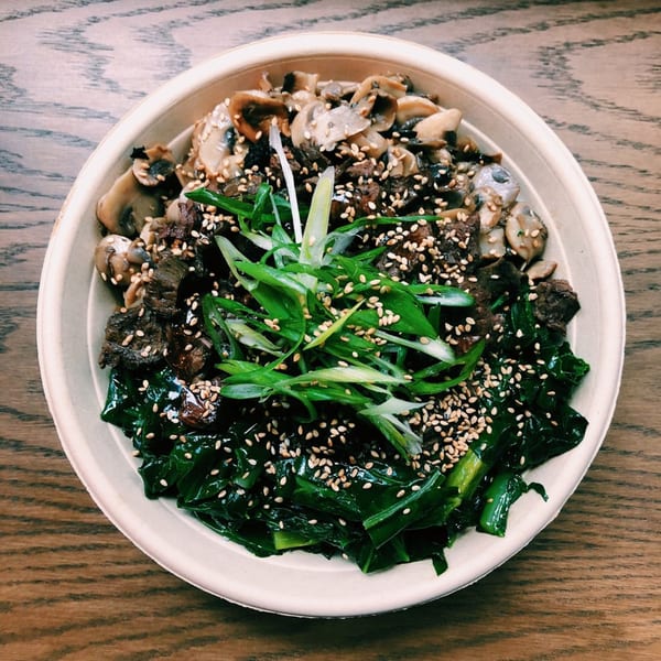 Mighty Bowl's Asian-fusion bowl with beef, mushrooms, green vegetables, green onions, and sesame seeds.